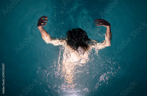 Dreamy portrait of woman inside the water at night