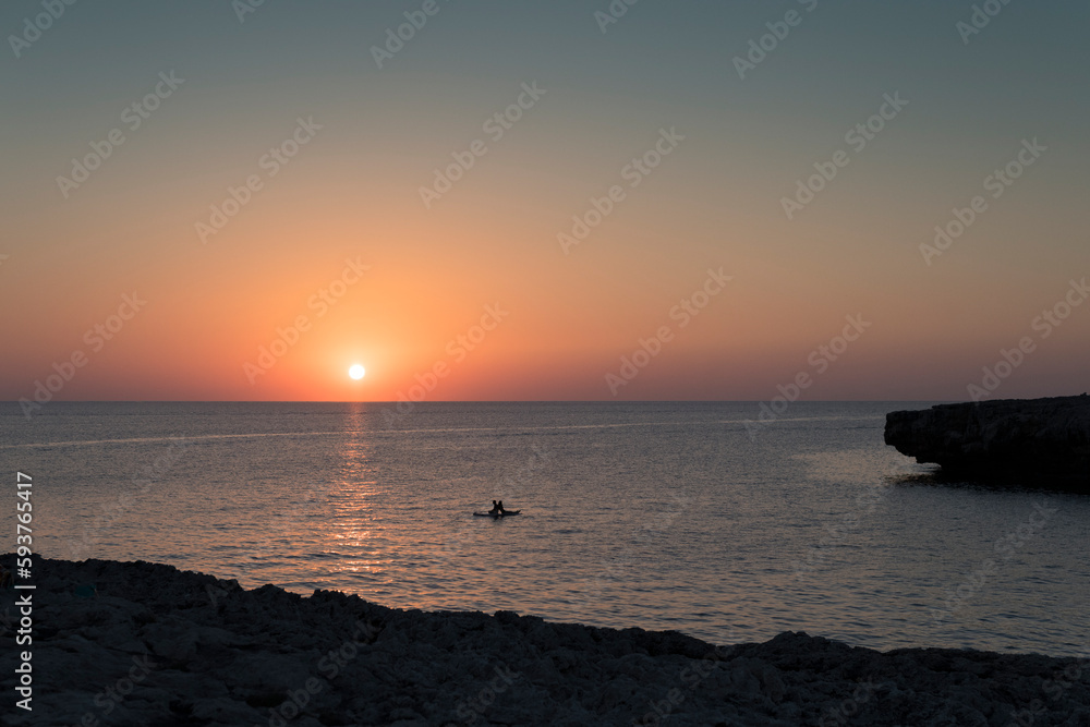 Relaxed couple enjoying sea sunset on paddle board Relaxed couple enjoying sea sunset on paddle board