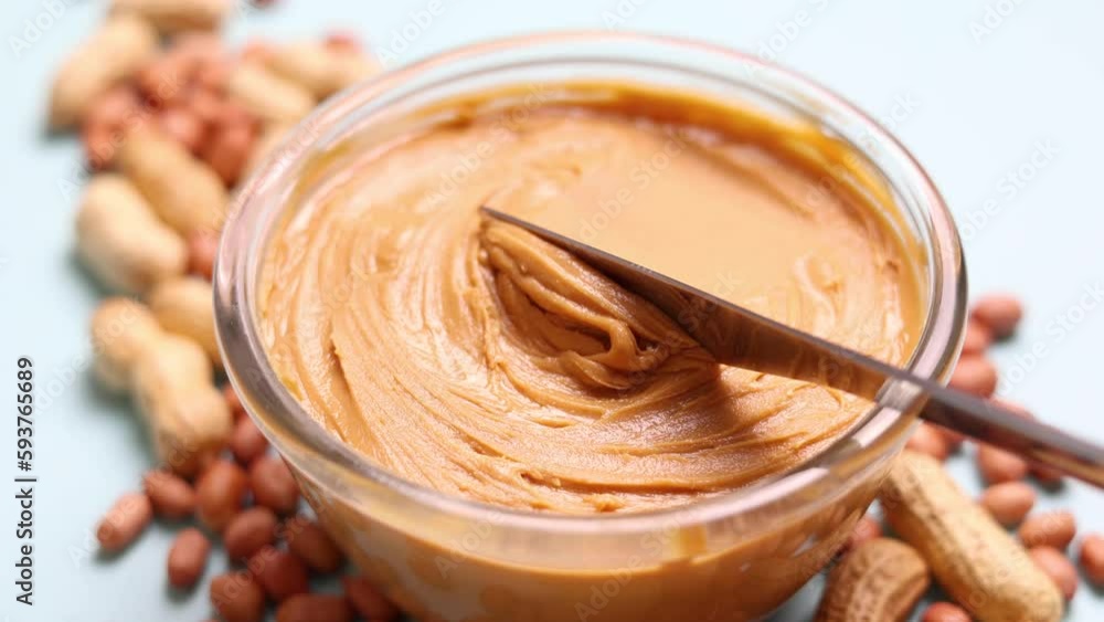 peanut butter and raw peanuts on a colored background peanut butter and raw peanuts on a colored background