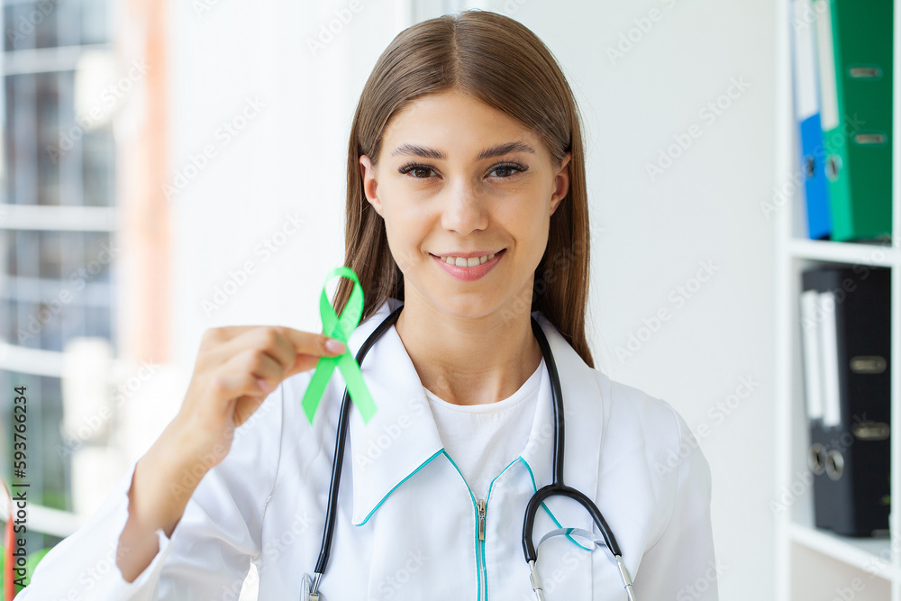 Green ribbon in hand as a symbol to awareness Lymphoma cancer Green ribbon in hand as a symbol to awareness Lymphoma cancer