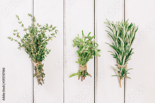Thyme, oregano and rosemary in bunches on the white table,