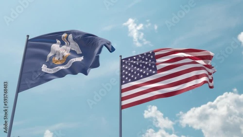 Louisiana and the USA on a flagpole realistic wave on strong wind in blue sky. State of Louisiana and The United States of America