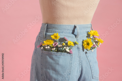 Woman with beautiful tender flowers in back pocket of jeans photo