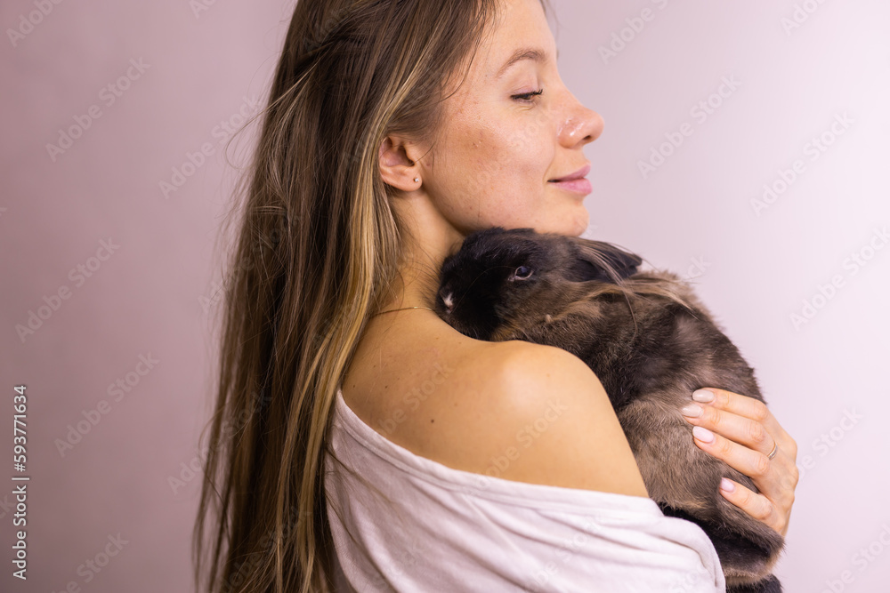Funny cute brown rabbit in pet's owner hands close-up. Bunny pet at home Funny cute brown rabbit in pet's owner hands close-up. Bunny pet at home