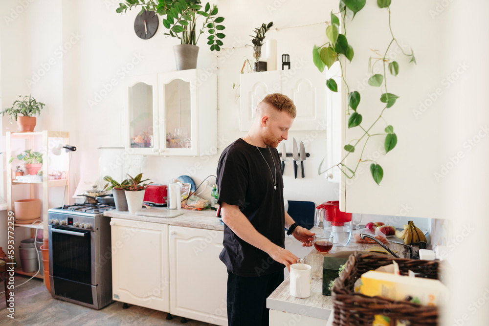 Male cooks food in kitchen. Male cooks food in kitchen.