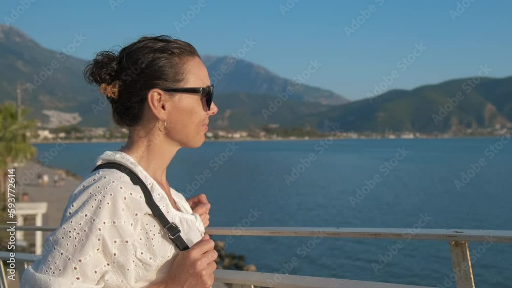 Beautiful female tourist enjoys the seascape. Beautiful female tourist enjoys the seascape.