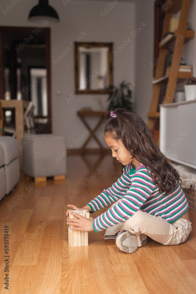 little girl playing with wooden blocks on the floor in the living little girl playing with wooden blocks on the floor in the living