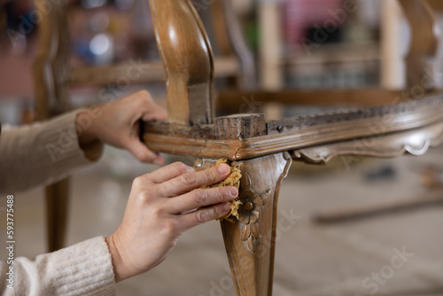 Close up of carpenter using rag while applying protective varnish to a piece of wood