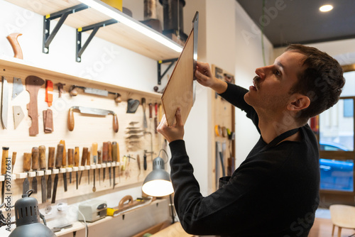 Luthier, Guitar Maker, Working In The Workshop.  photo