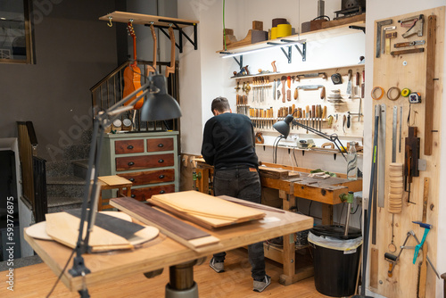 Luthier, Guitar Maker, Working In The Workshop.  photo