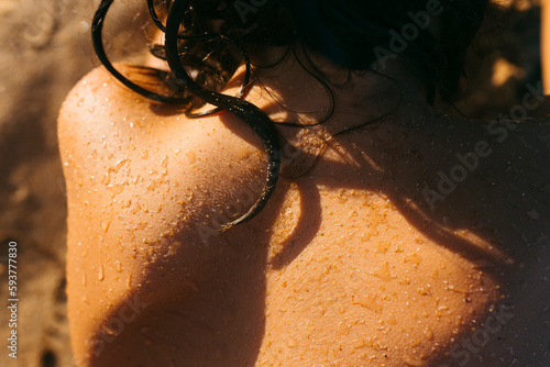 Child's damp back in sunlight in the beach photo