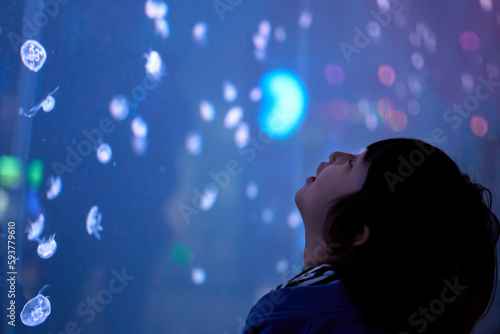 Cute Asian boy watching jellyfish in aquarium