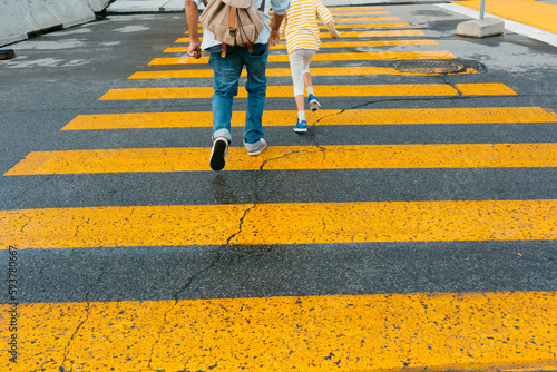 Anonymous Man and kid crossing pedestrian cross 