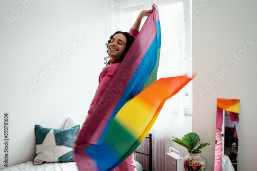 Man playing with an lgbt rainbow flag at home photo