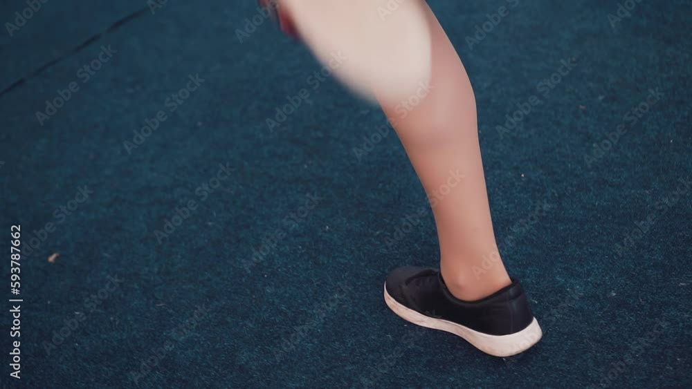 Shooting the legs of a girl dancing in sneakers and a dress on the dance floor Shooting the legs of a girl dancing in sneakers and a dress on the dance floor