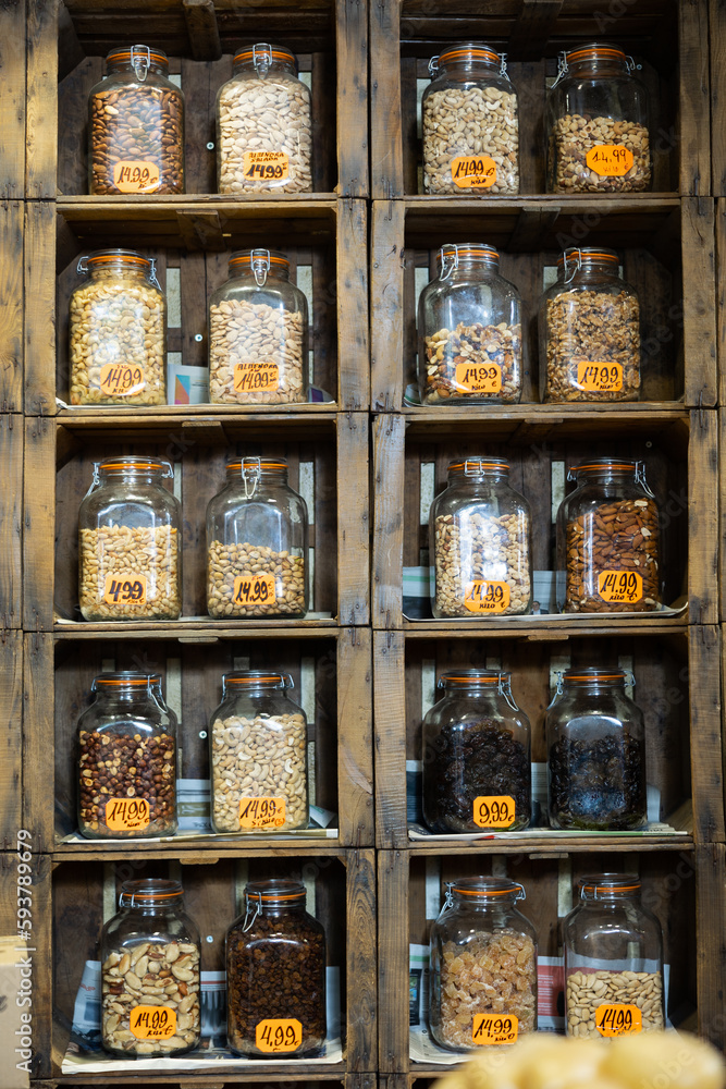 Glass jars with various nuts on grocery store shelves