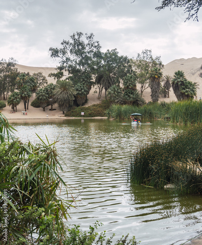 people taking a boat ride in the huacachina lagoon ica peru