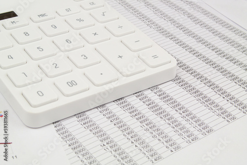 White calculator on financial data papers. Accountancy concept. 