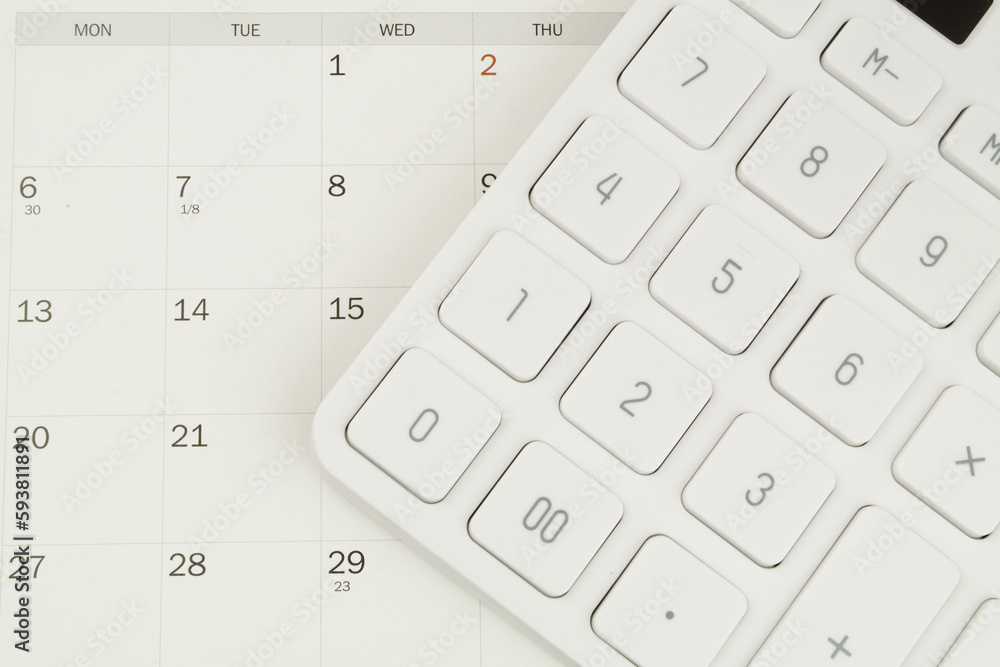 Top view of white modern calculator on calendar. Business scheduler concept. Top view of white modern calculator on calendar. Business scheduler concept.