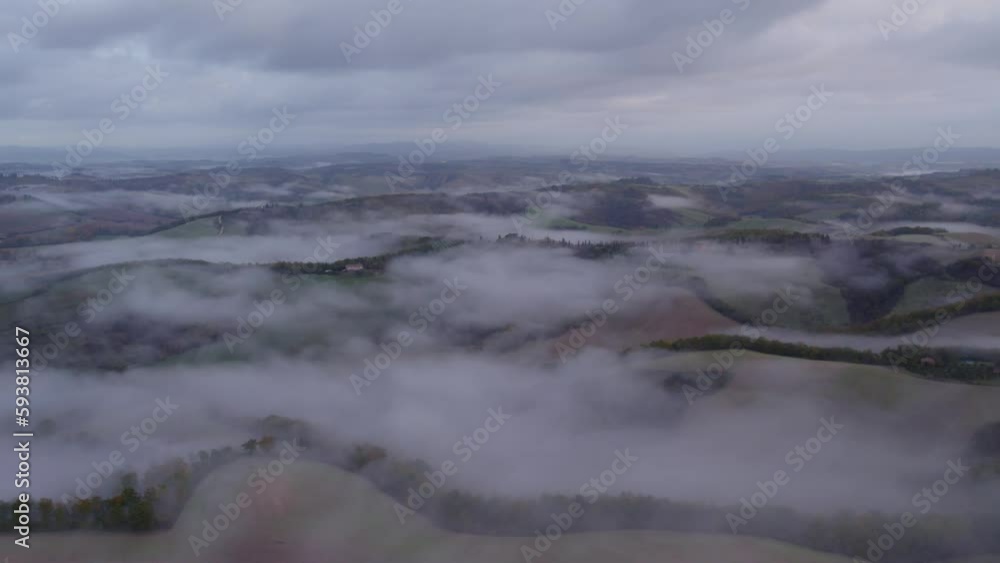 Rolling hills of Tuscany covered in mist before sunrise, aerial Rolling hills of Tuscany covered in mist before sunrise, aerial
