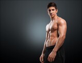 Hot muscular man model on dark background.