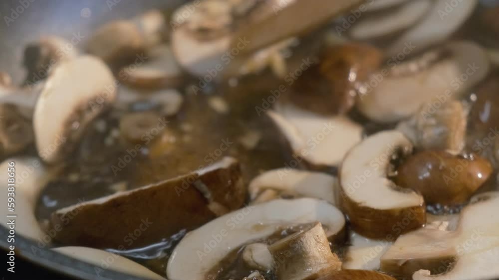 Close up of fresh sliced mushrooms cooking in a pan for a delicious healthy recipe Close up of fresh sliced mushrooms cooking in a pan for a delicious healthy recipe