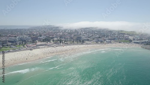 Jam-packed Bondi Beach In Sydney, Australia With Crowds Of Sunbathers And Swimmers In Summer. aerial pullback