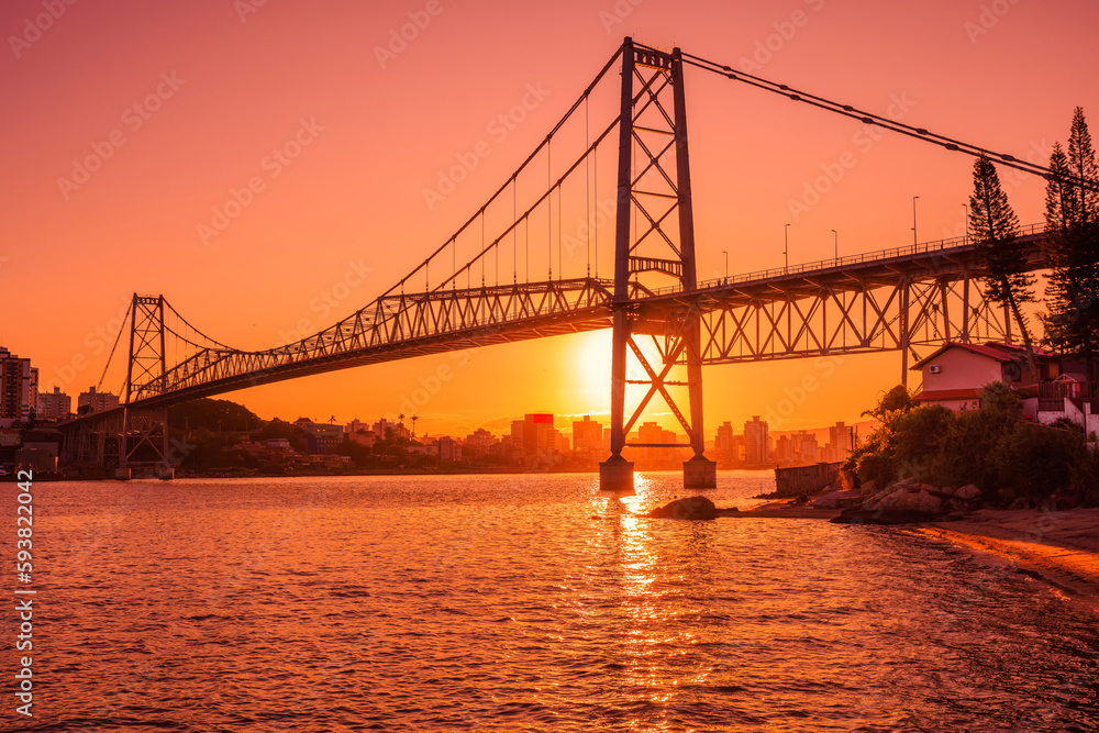 Hercilio luz bridge with warm sunset and reflection on water in Florianopolis