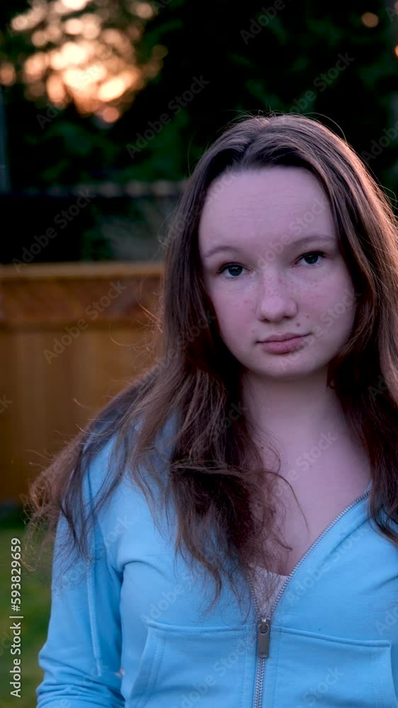 Vertical video. Portrait of a beautiful young girl looking into camera and smiling. A charming woman dressed in a luxurious is standing on the street. Vertical video. Portrait of a beautiful young girl looking into camera and smiling. A charming woman dressed in a luxurious is standing on the street.