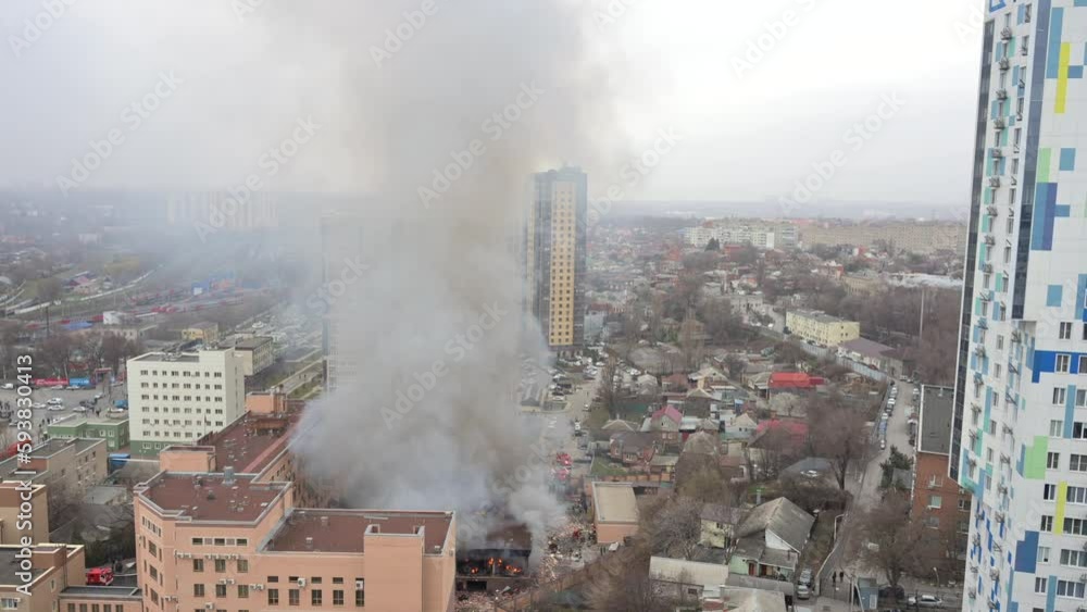 Aerial view of firefighters extinguishing fire in industrial or living area, near high office building after explosion of natural gas Aerial view of firefighters extinguishing fire in industrial or living area, near high office building after explosion of natural gas