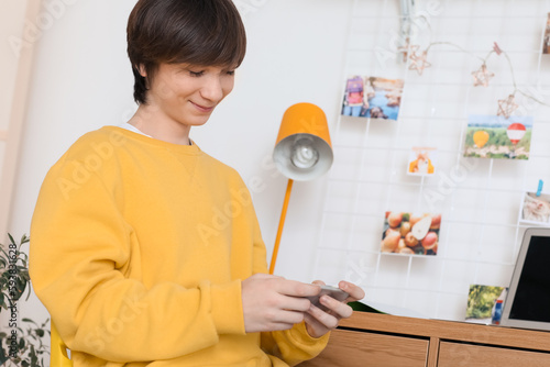 Teenage boy using mobile ph...
