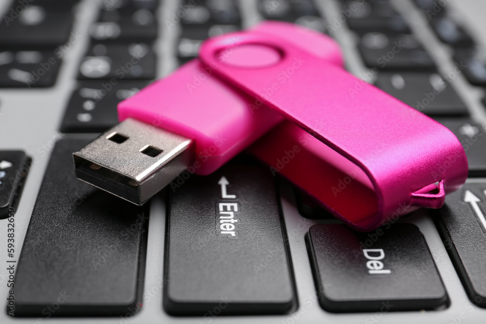 Fototapeta premium Pink USB flash drive on modern laptop, closeup