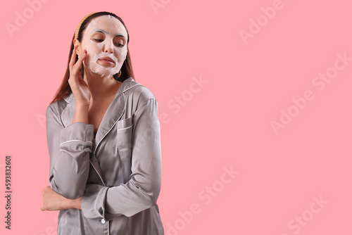 Young woman with sheet mask...