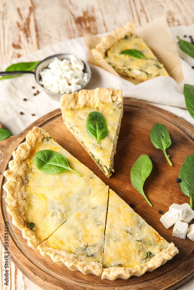 Board with pieces of delicious quiche and cottage cheese on white wooden background