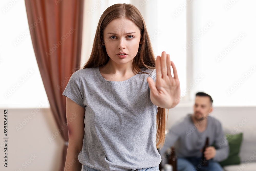 Bruised young woman showing stop gesture at home. Domestic violence concept Bruised young woman showing stop gesture at home. Domestic violence concept
