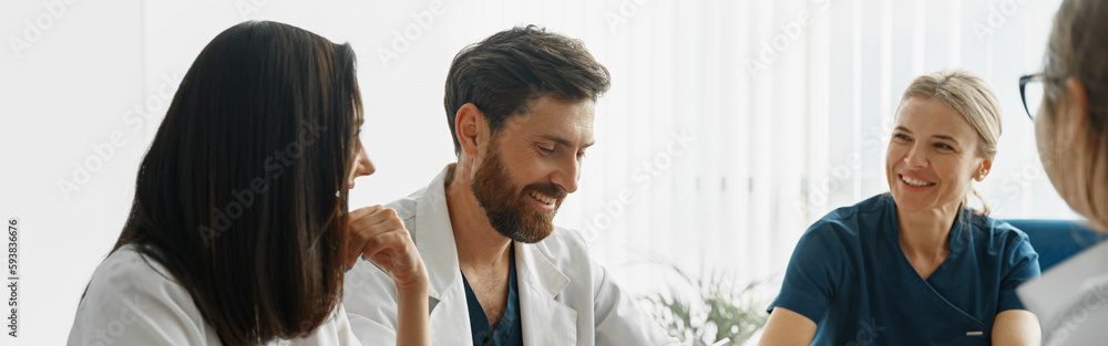 Group of doctors sitting at meeting table in conference room during medical seminar Group of doctors sitting at meeting table in conference room during medical seminar