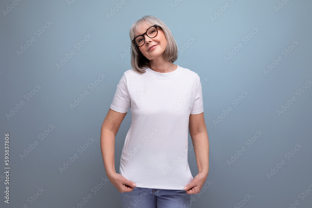 Fototapeta premium a mature woman of retirement age is in menopause in a white tank top on a studio background