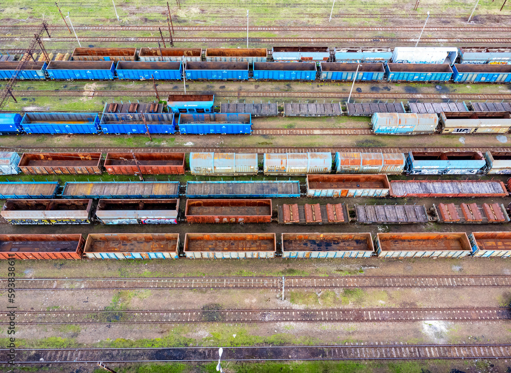 Aerial view of freight trains. Aerial view from flying drone of colorful freight trains at railroad station. Carriages of goods on a railroad. Heavy industry. Industrial conceptual scene with trains.