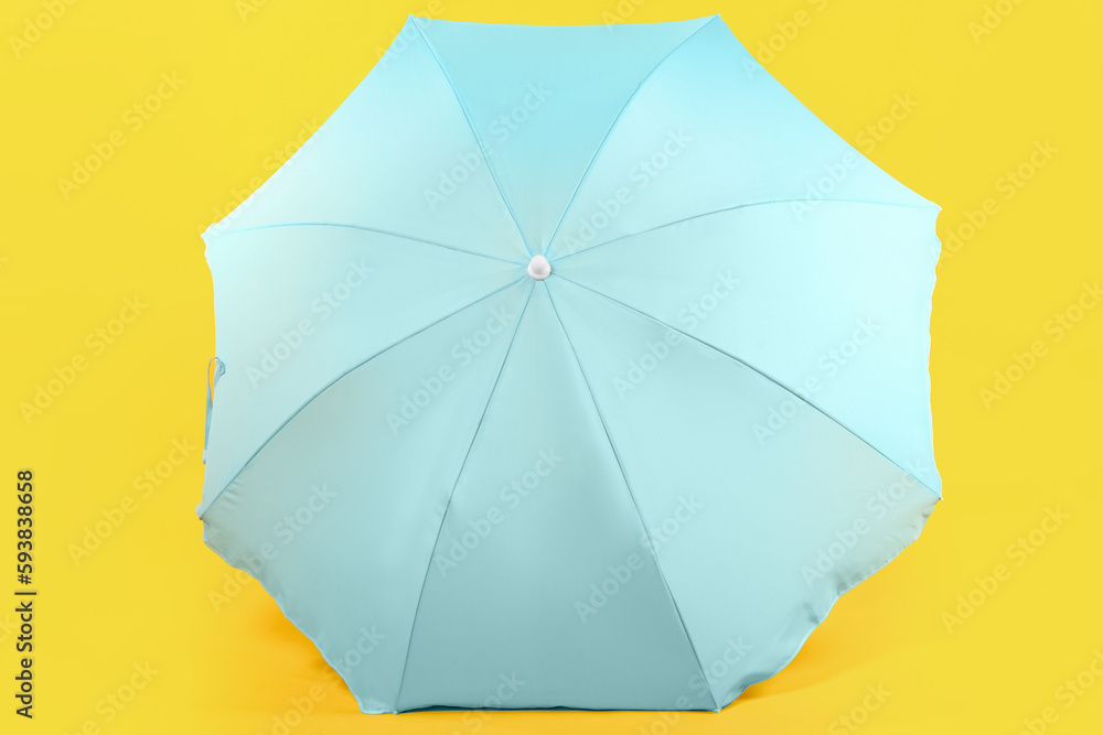Blue beach umbrella on yellow background Blue beach umbrella on yellow background