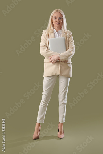 Mature woman with laptop on...