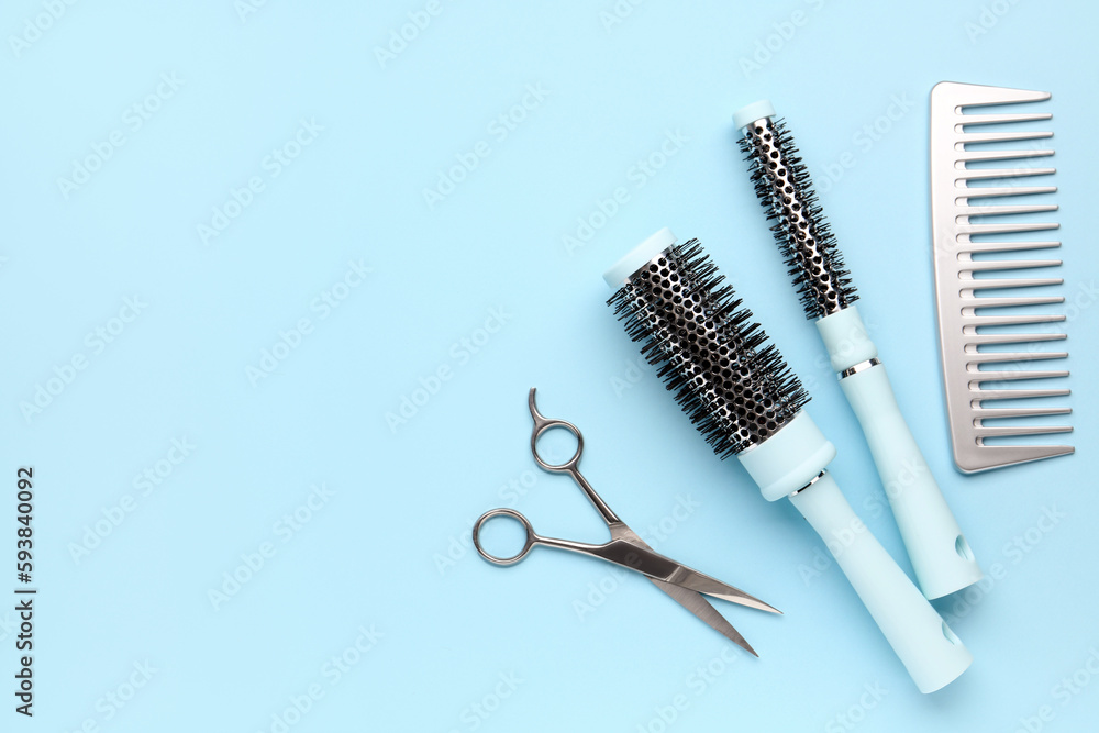 Hair brushes with scissors on blue background Hair brushes with scissors on blue background
