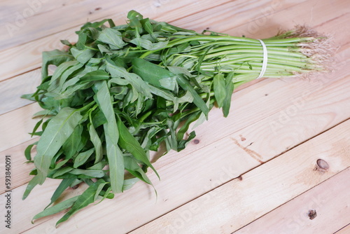 Water Convolvulus for Water spinach or Morning Glory on Wooden background. in Indonesian it is called kangkung photo