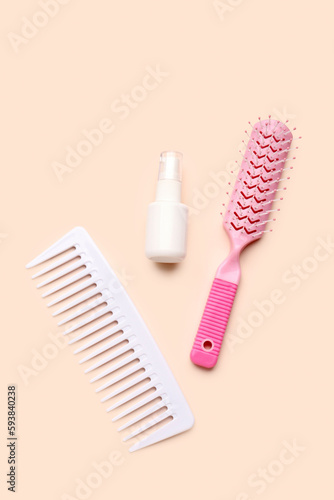 Hair brushes with spray bottle on beige background