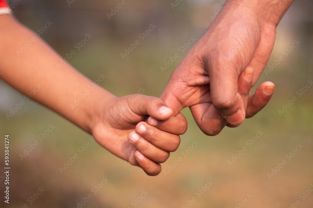 A Children hold his father's hand and the Background blur A Children hold his father's hand and the Background blur