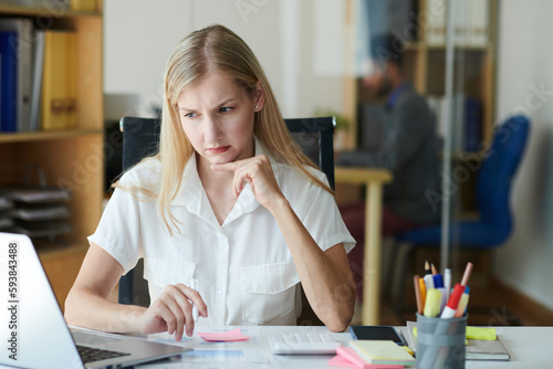 Wall Mural Frowning unhappy businesswoman reading e-mail on laptop screen