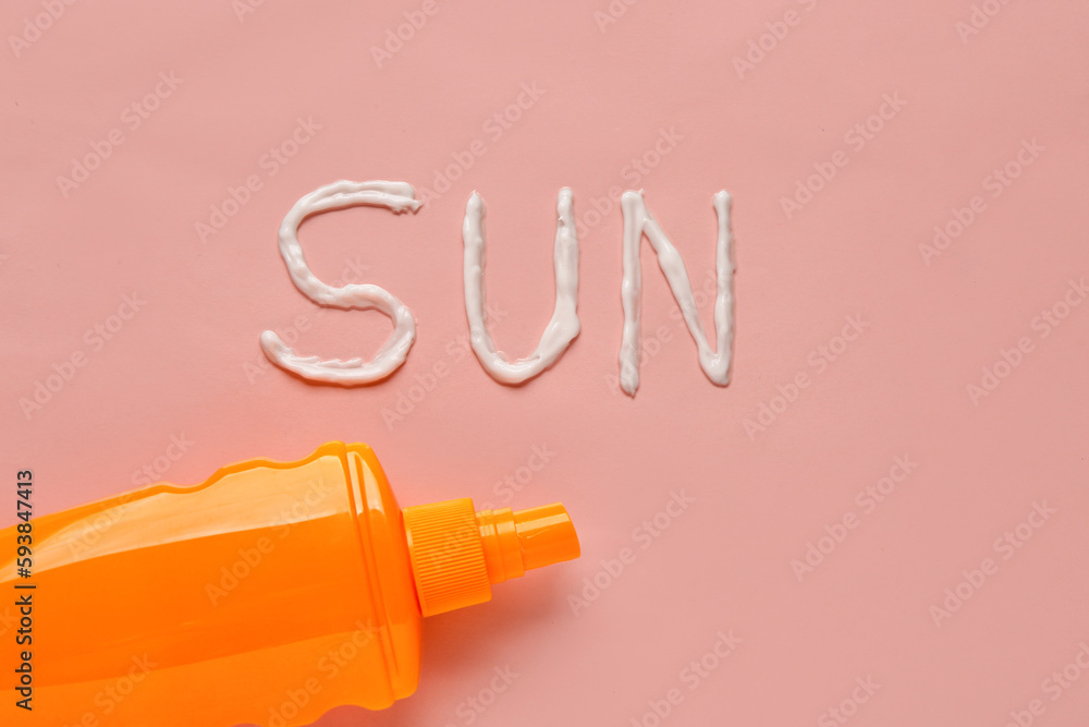 Word SUN made of sunscreen cream on pink background Word SUN made of sunscreen cream on pink background
