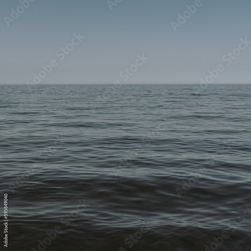 Beautiful deep blue sea with frothy waves. Minimal composition with neutral colours. Summer travel concept. Natural background