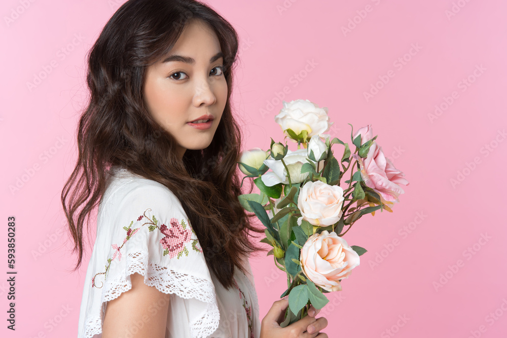 Young Asian woman holding a bouquet on hand isolated pink color background Young Asian woman holding a bouquet on hand isolated pink color background