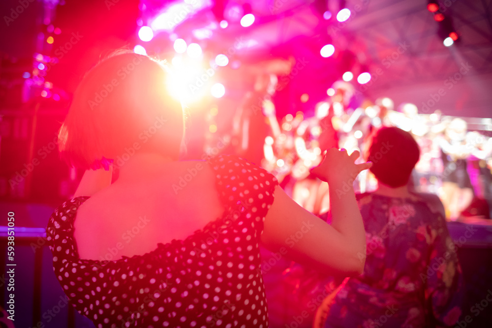 Woman dancing during concert against neon light Woman dancing during concert against neon light