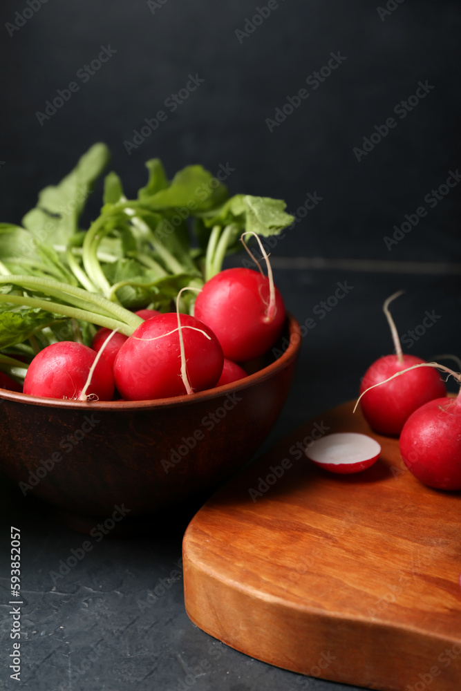 Bowl of ripe radish with green leaves on dark background, closeup Bowl of ripe radish with green leaves on dark background, closeup